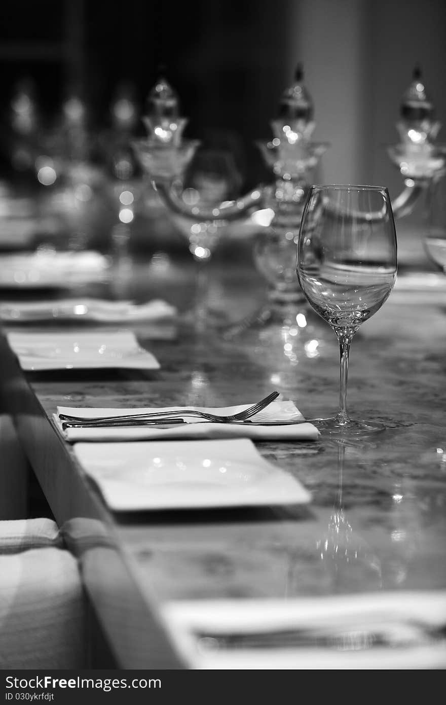 Candle lights and a glass on the table in the restaurant, b&w