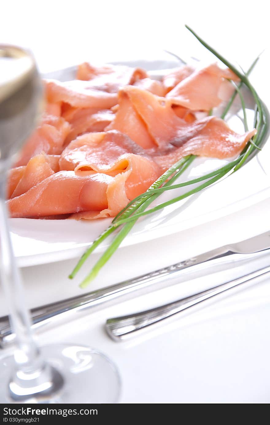 Smoked salmon with chives an a white table. Smoked salmon with chives an a white table