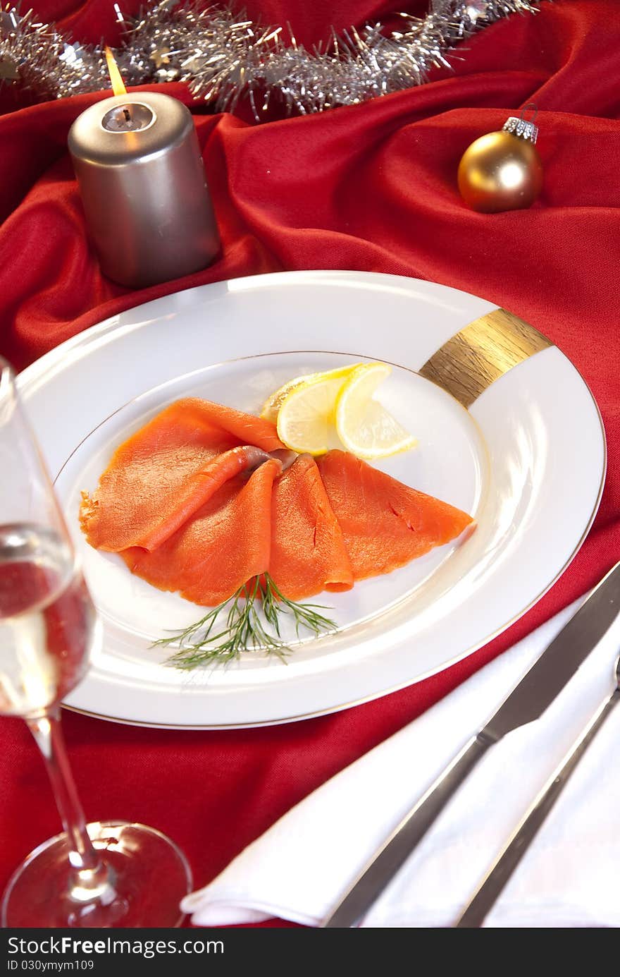 Smoked salmon with chives for Christmas, on a red-decorated table. Smoked salmon with chives for Christmas, on a red-decorated table