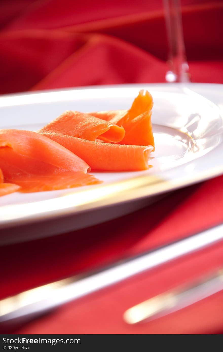 Smoked salmon with chives for Christmas, on a red-decorated table. Smoked salmon with chives for Christmas, on a red-decorated table