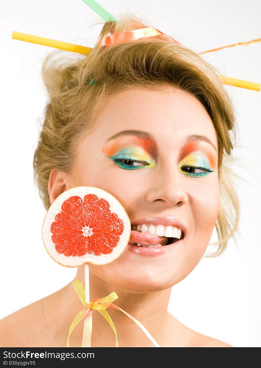 Amazing girl tries to lick a piece of grapefruit on a stick. Amazing girl tries to lick a piece of grapefruit on a stick