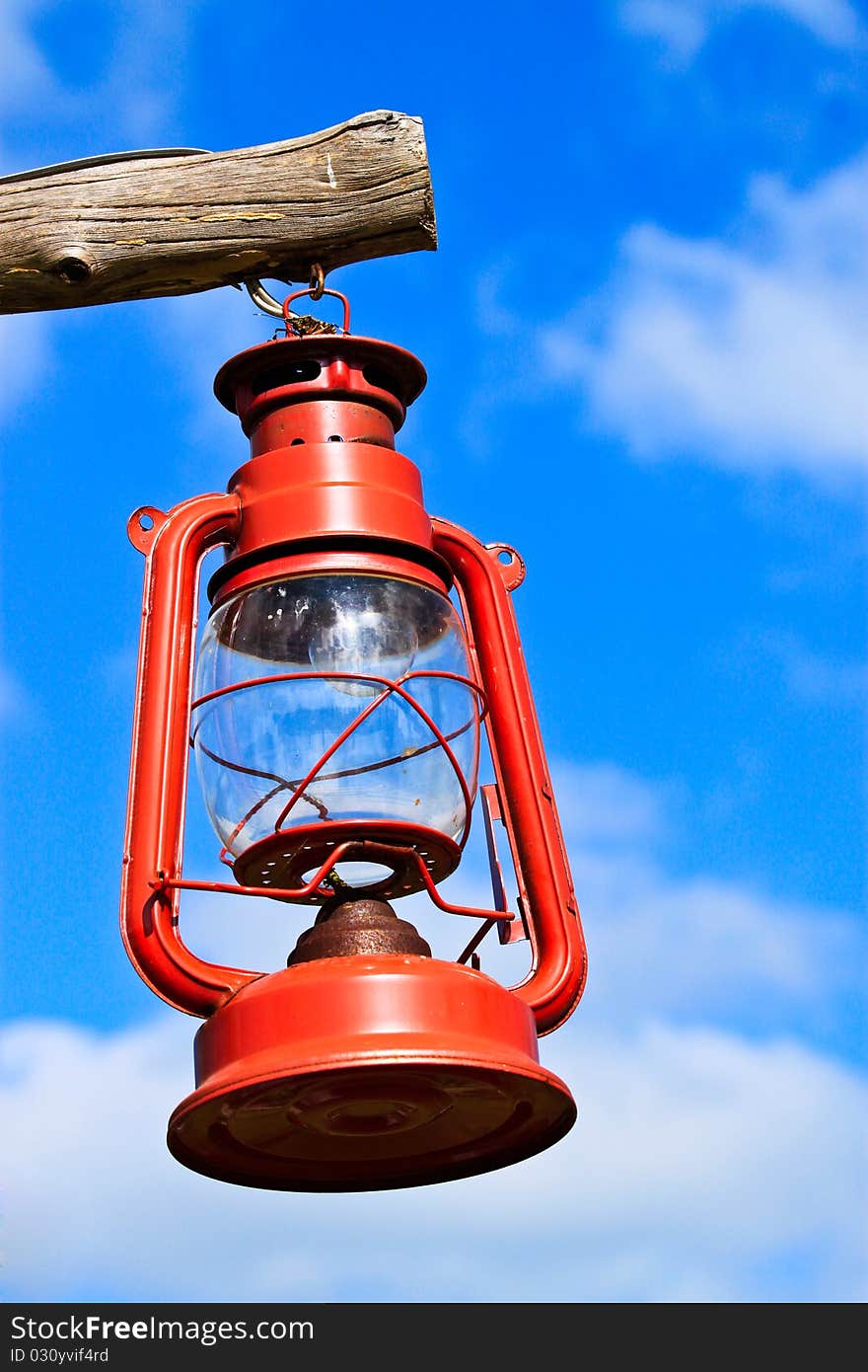 Old red lantern hanging by wood on blue sky. Old red lantern hanging by wood on blue sky