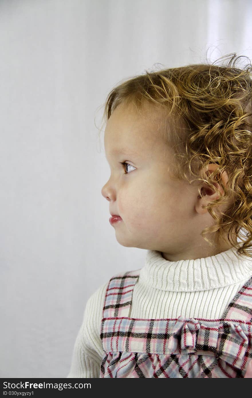 Profile of a young girl with curly hair looking determined. Profile of a young girl with curly hair looking determined.