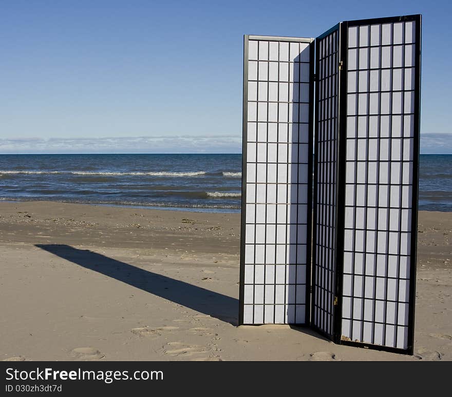 A black and white three-fold screen on the beach of a lake. A black and white three-fold screen on the beach of a lake.