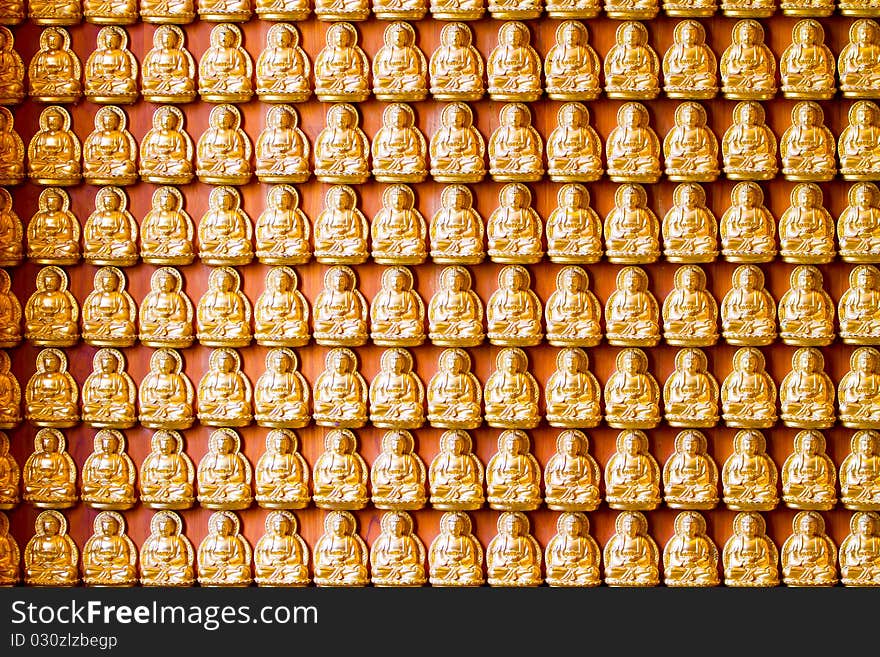 Many small Buddha statue near the temple wall.