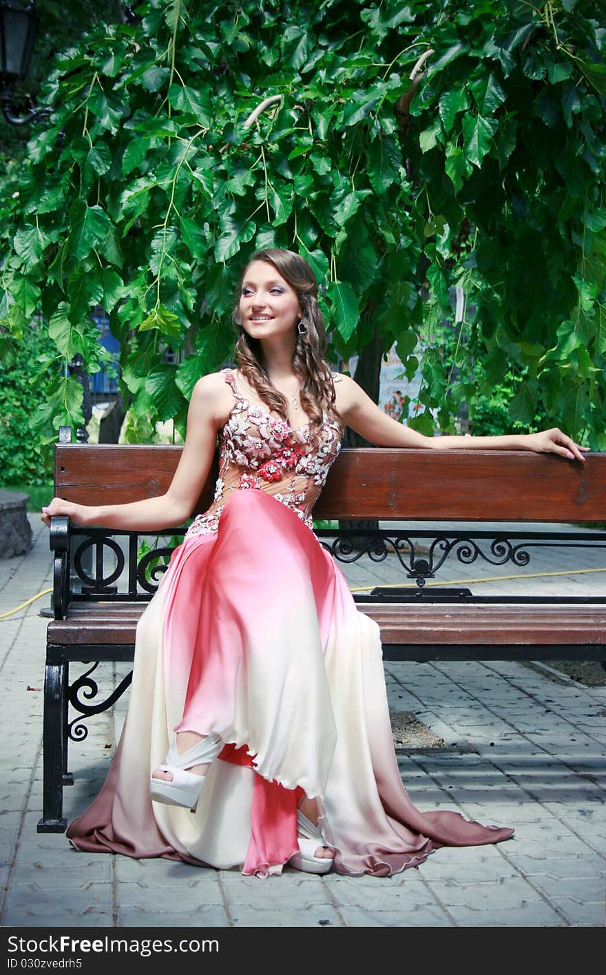 Beautiful young lady in the park sitting on the bench