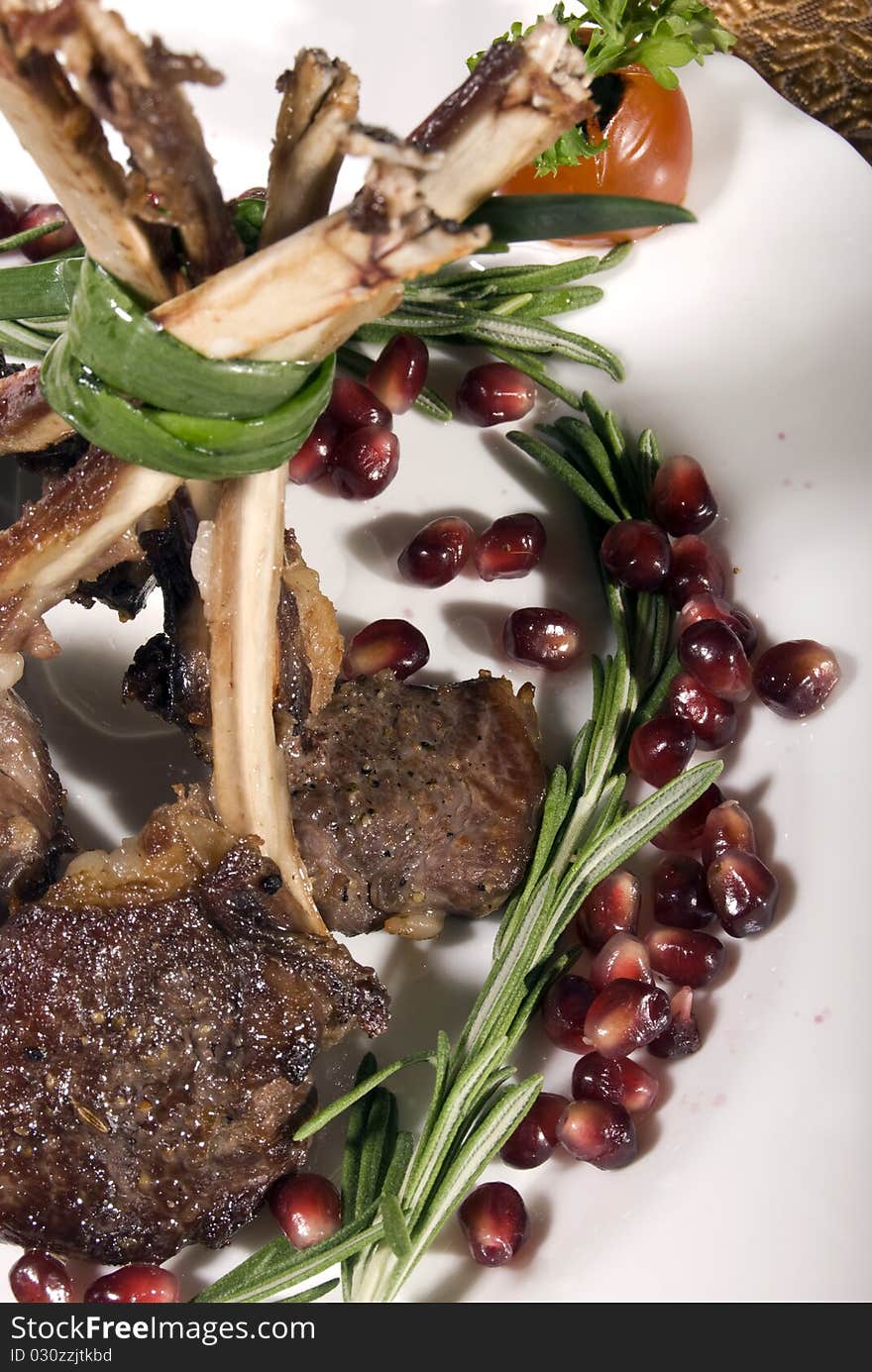 Fried rib served with pomegranate and salad. Fried rib served with pomegranate and salad