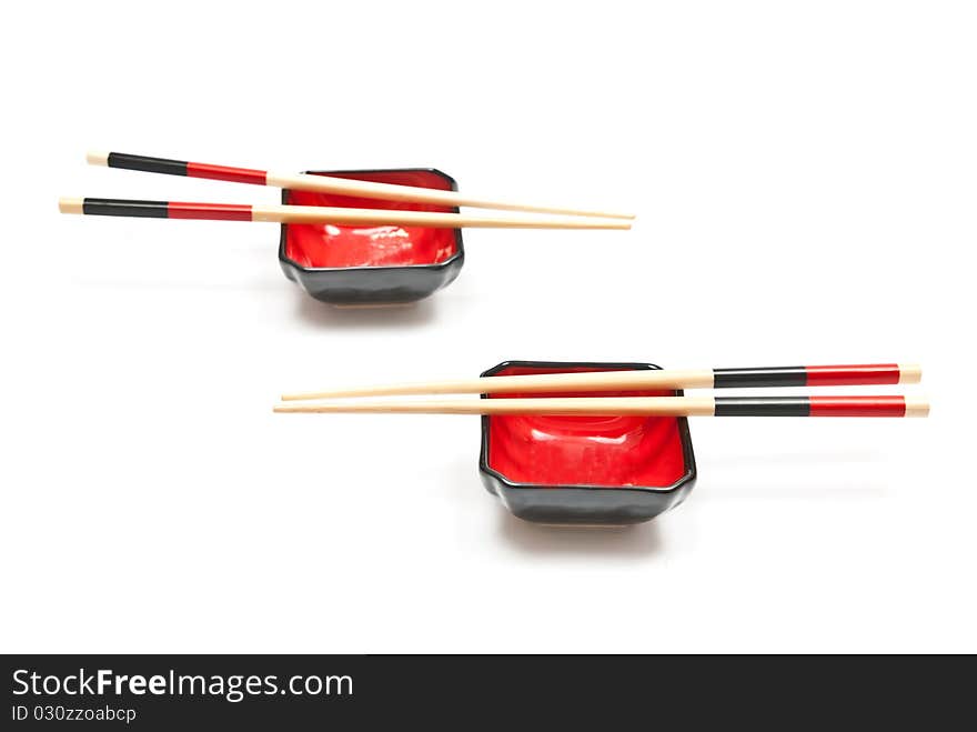 Black and red sushi set (chopsticks and plate) isolated on white background. Black and red sushi set (chopsticks and plate) isolated on white background