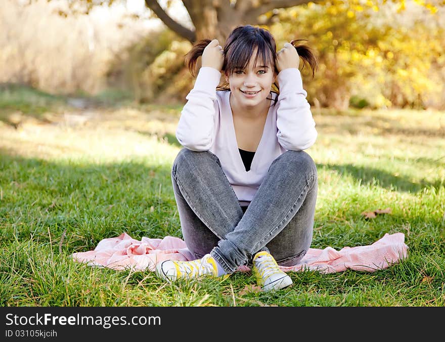 Beautiful brunette girl at the park. Outdoor shot.