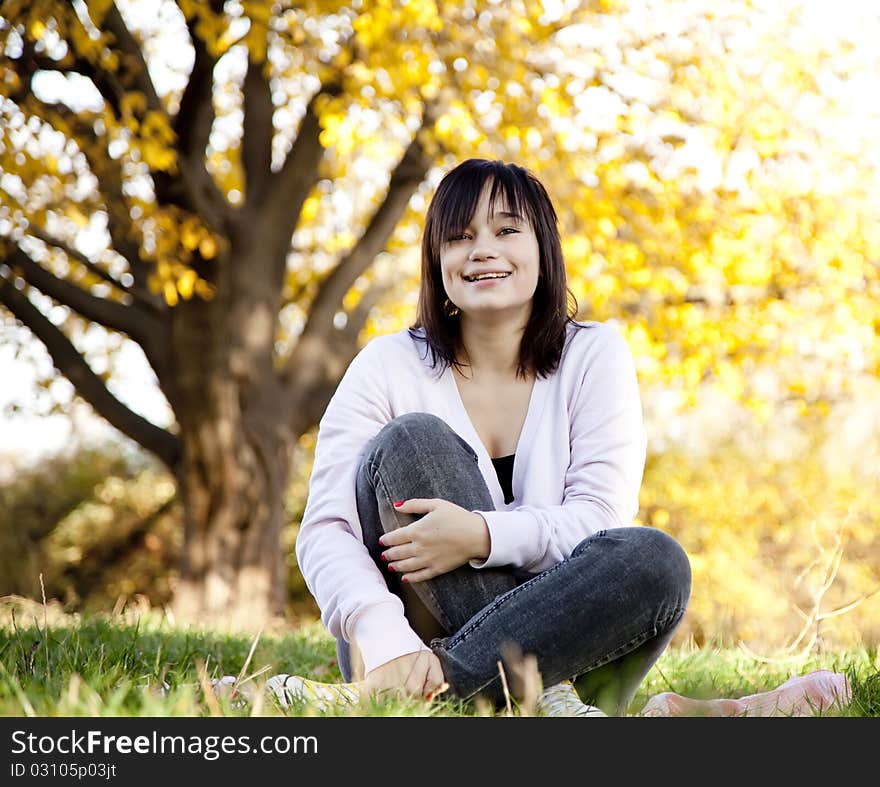 Beautiful brunette girl at the park. Outdoor shot.