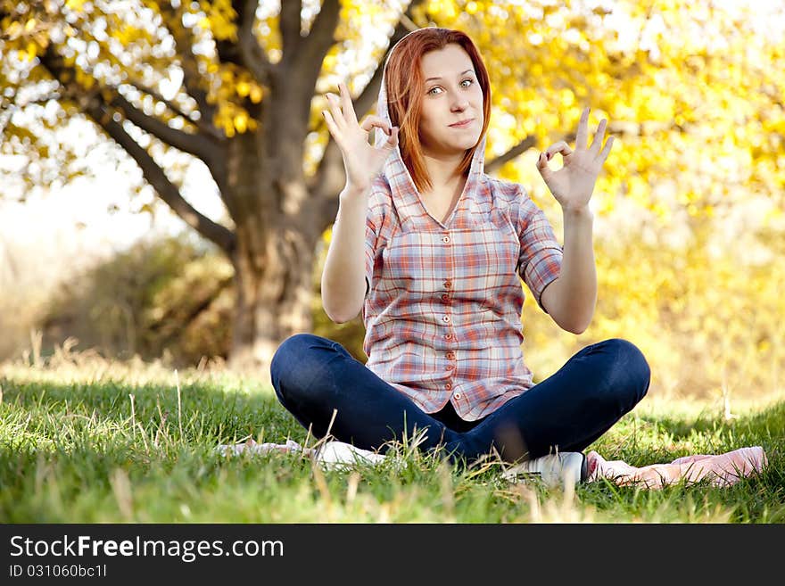 Portrait of red-haired girl in the autumn park.