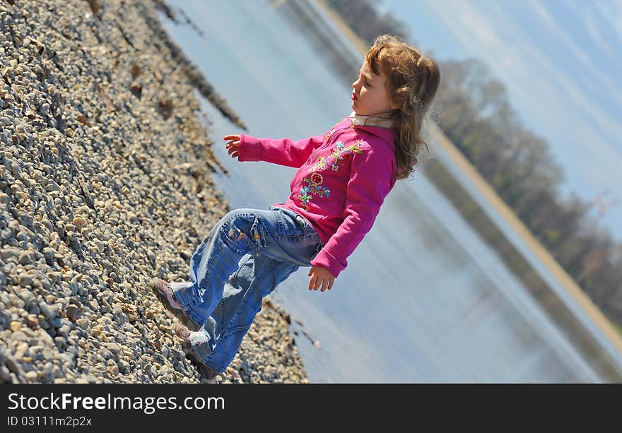 Little girl playing at the beach in winter