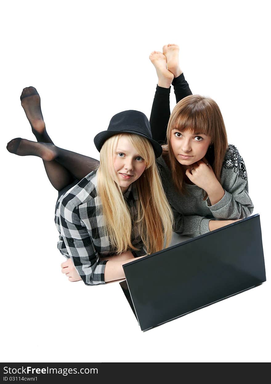 Two girls lies with computer on white background