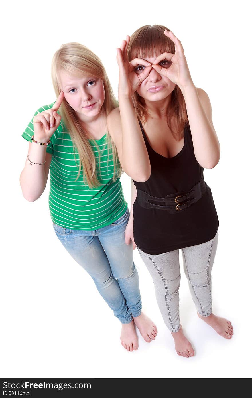 Two girls stand and make faces on white background