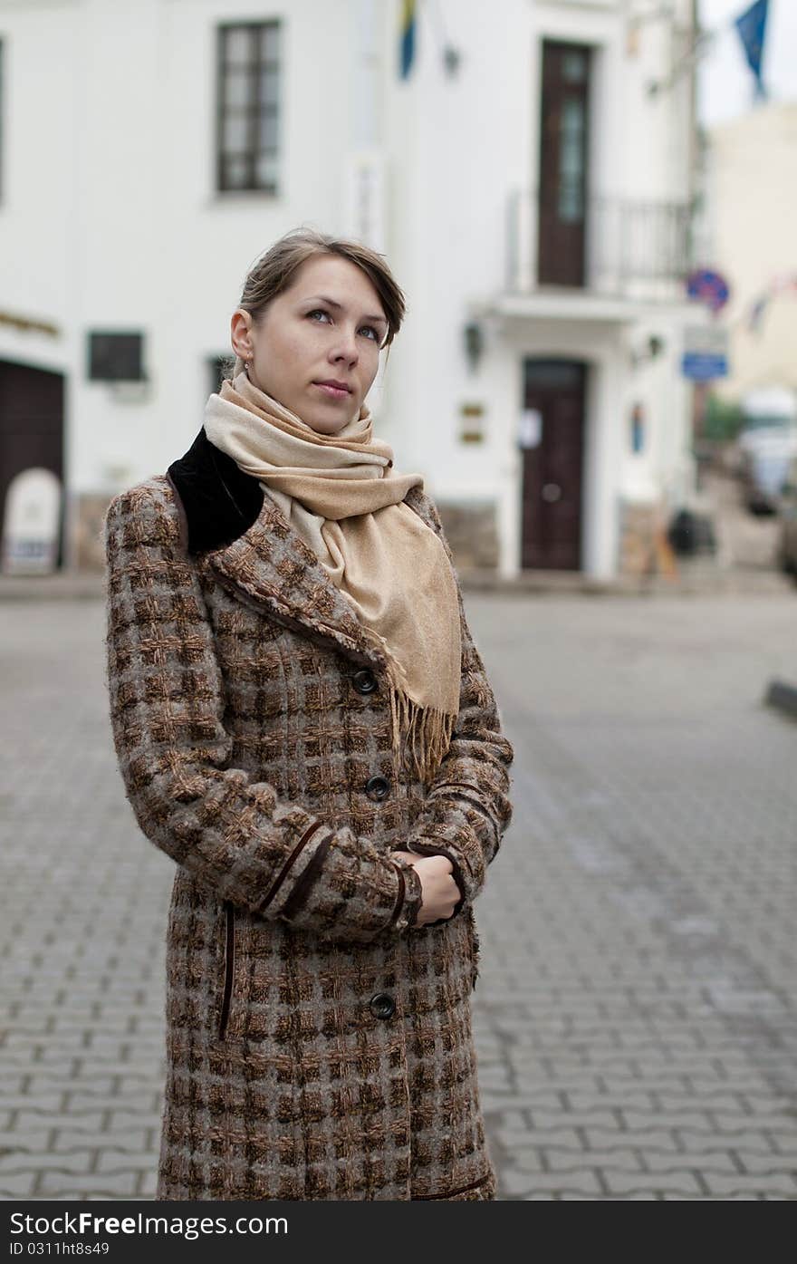 Woman in the autumn city in the coat. Woman in the autumn city in the coat