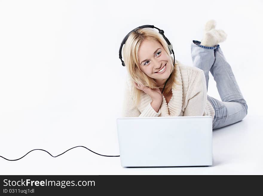 Young girl in headphones with a laptop on a white background. Young girl in headphones with a laptop on a white background