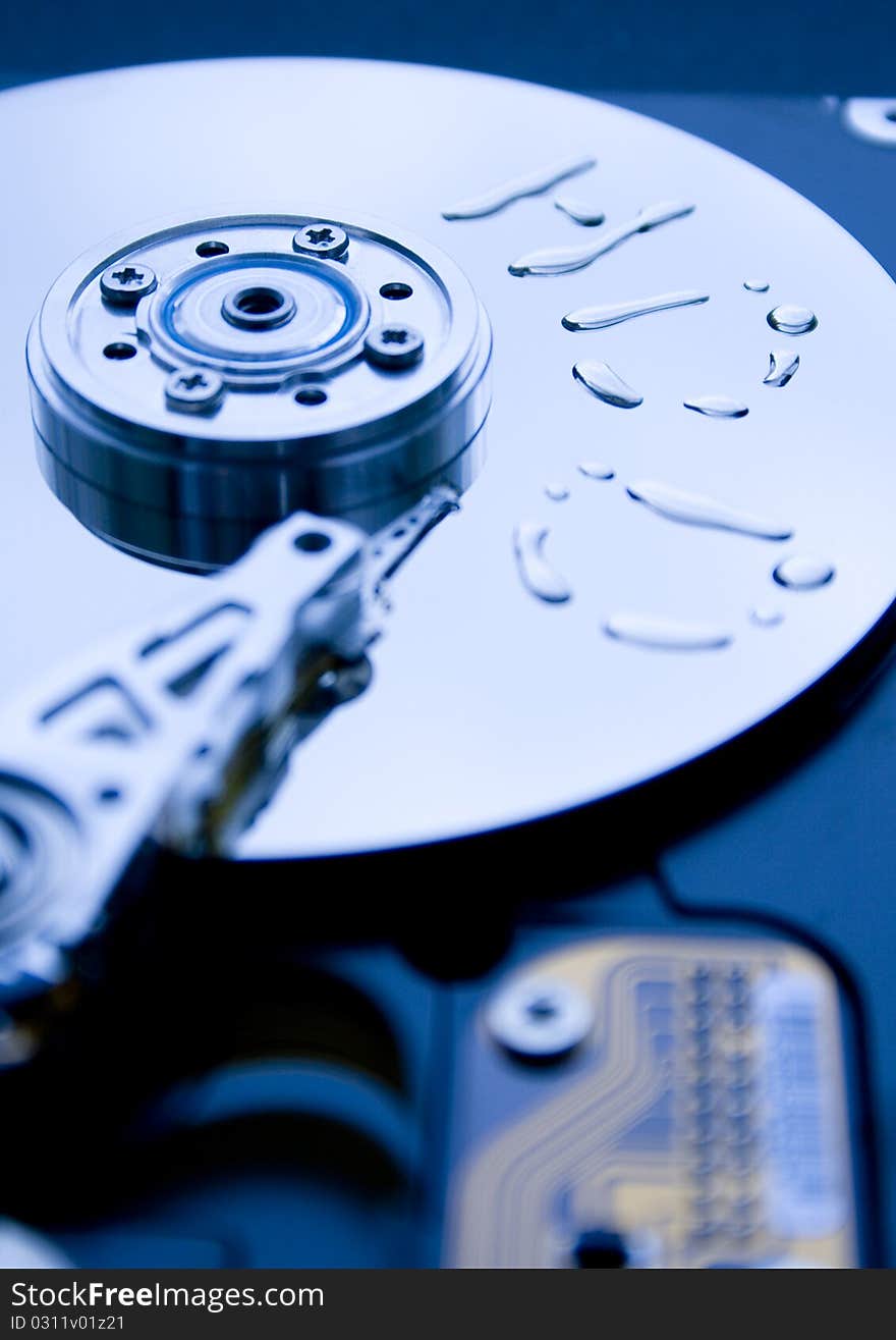 Closeup of read/write head of a computer hard drive and the word formed from water drops. Closeup of read/write head of a computer hard drive and the word formed from water drops.