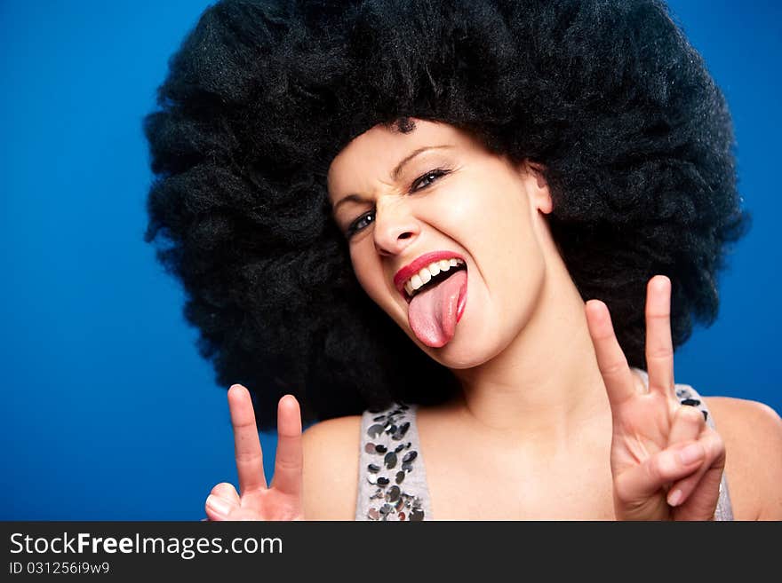 Portrait of a beautiful woman with huge afro haircut isolated on blue