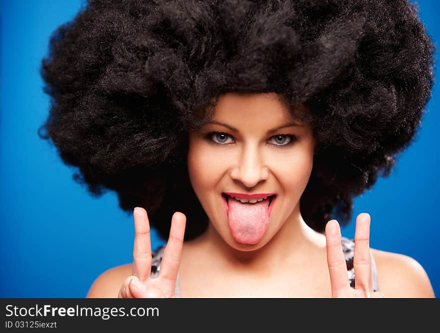 Portrait of a beautiful woman with huge afro haircut isolated on blue