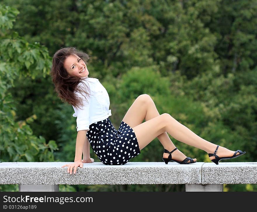 Happy young woman sitting in the park. Happy young woman sitting in the park