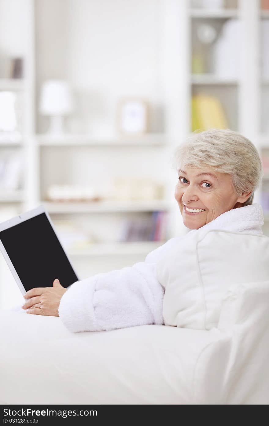 A smiling middle-aged woman with a laptop. A smiling middle-aged woman with a laptop