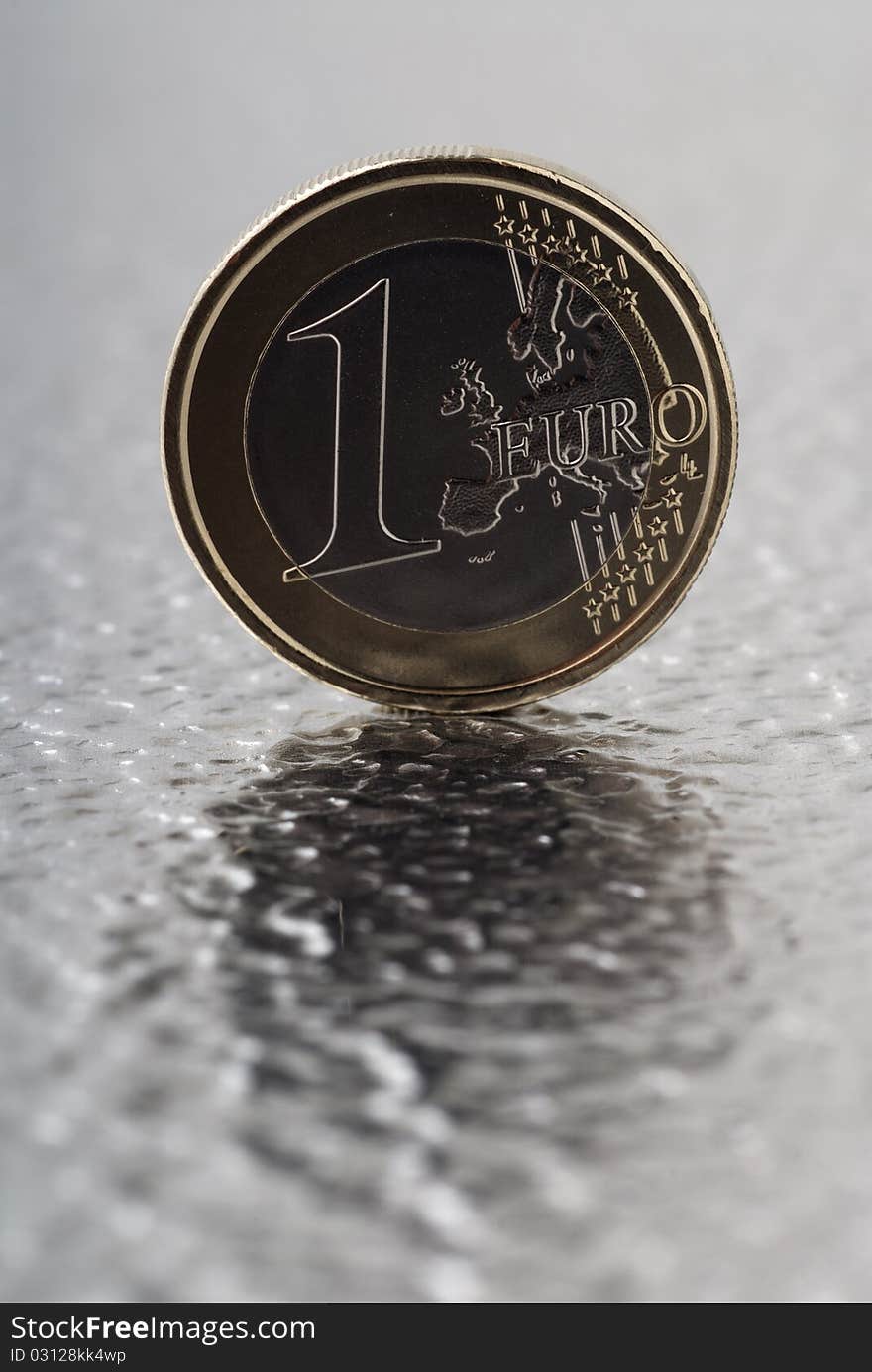 A one Euro coin on a flat metal