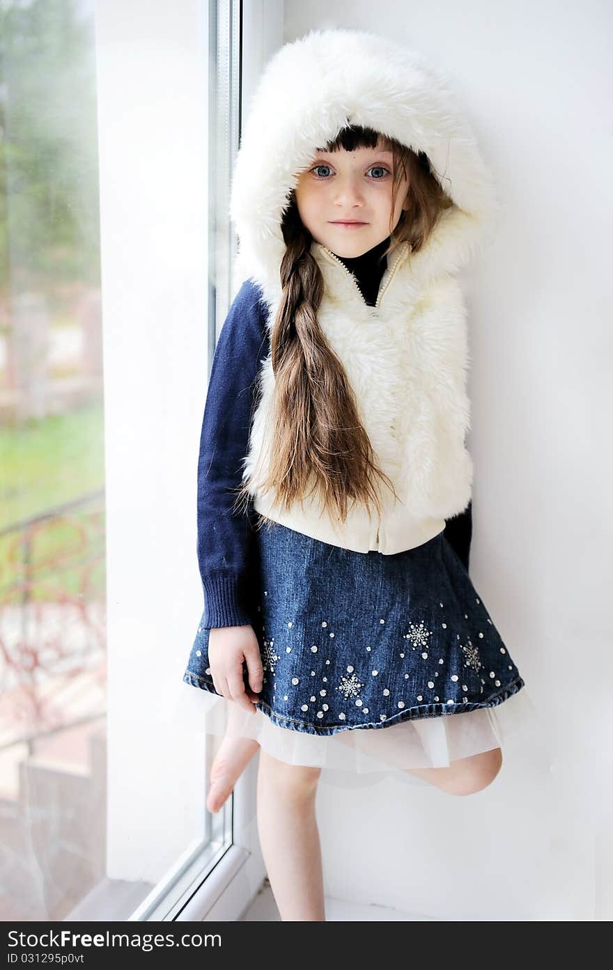 Adorable small girl in white fur hood