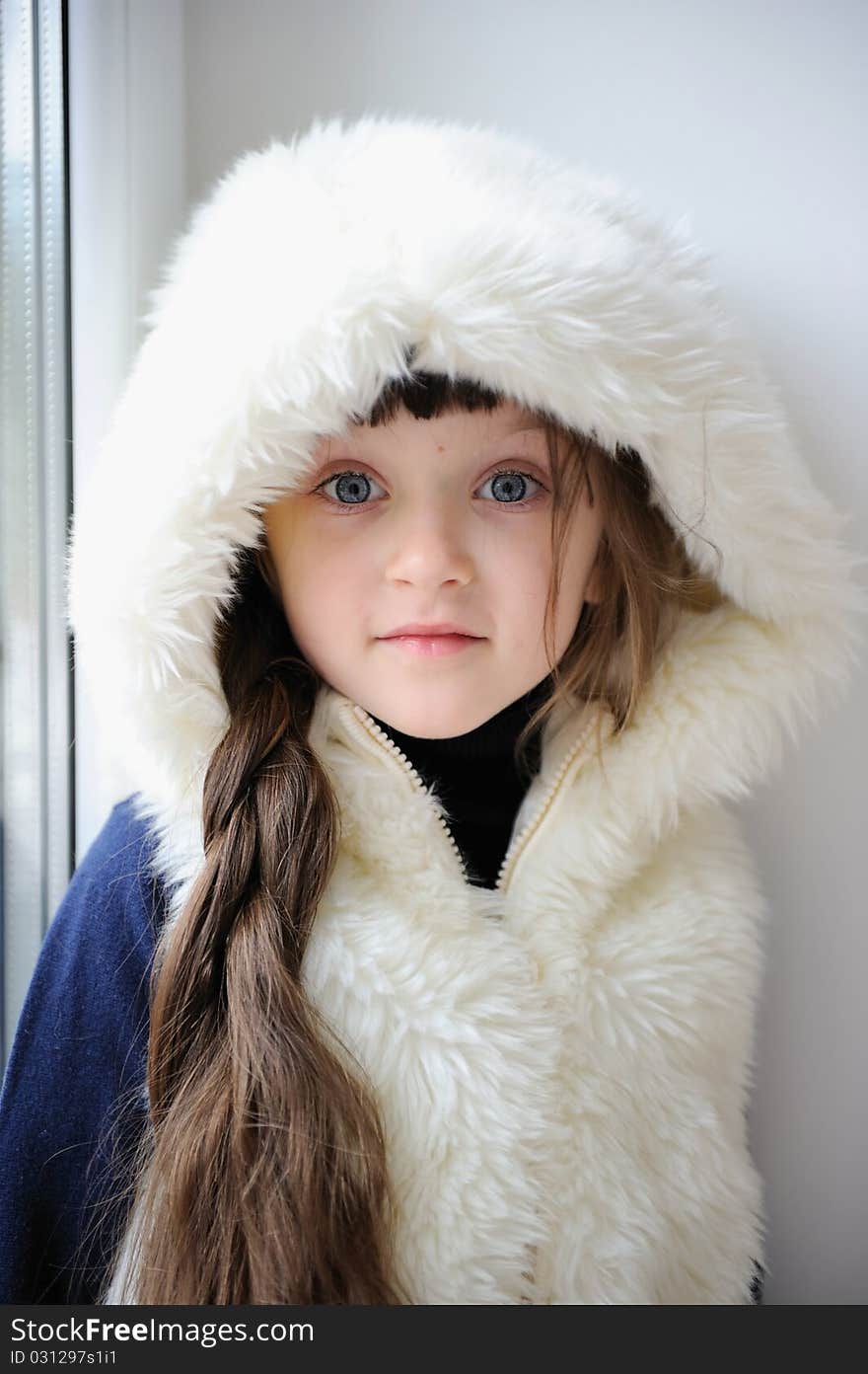 Adorable small girl in white fur hood