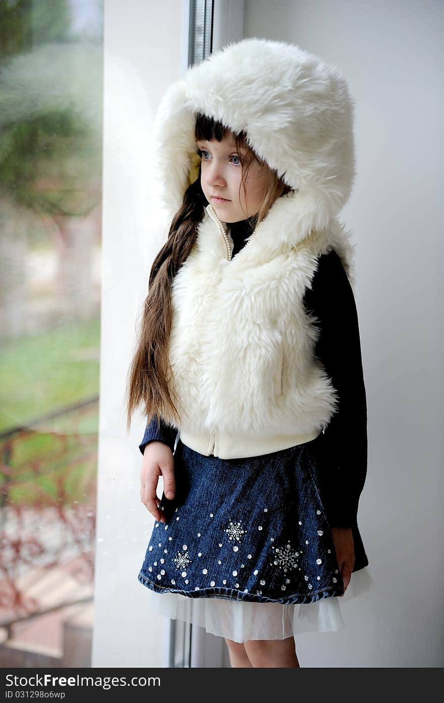 Adorable small girl in white fur hood