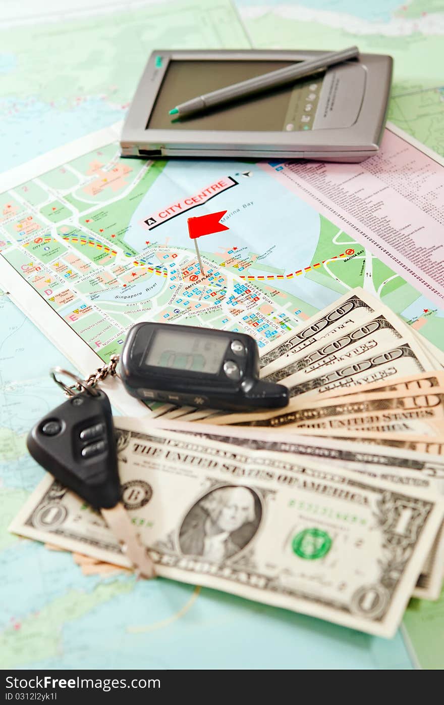 Road map with a red flag, car keys, electronic organizer and money. closeup. Road map with a red flag, car keys, electronic organizer and money. closeup.