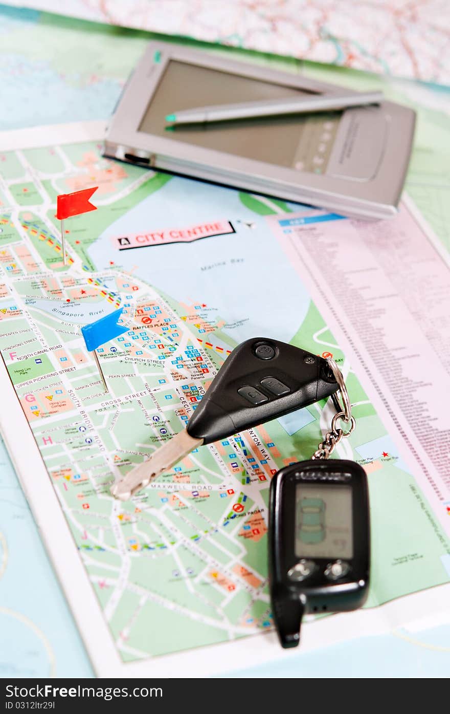 Road map with a red and blue flag, car keys, electronic organizer. closeup. Road map with a red and blue flag, car keys, electronic organizer. closeup.