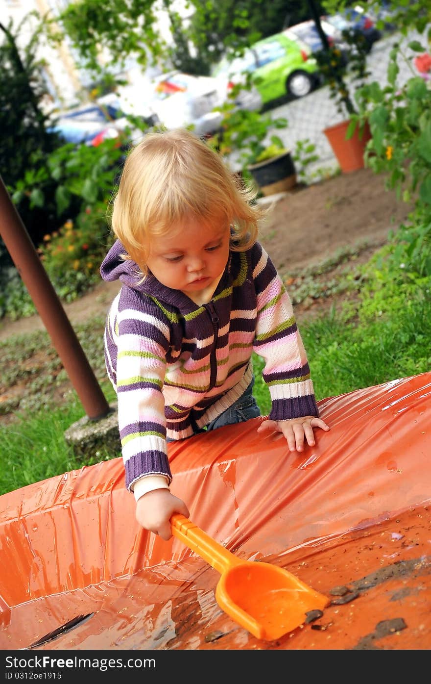 Girl Playing With Shovel In Th Water