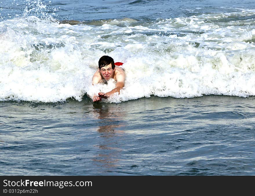 Young boy is body surfing in the waves