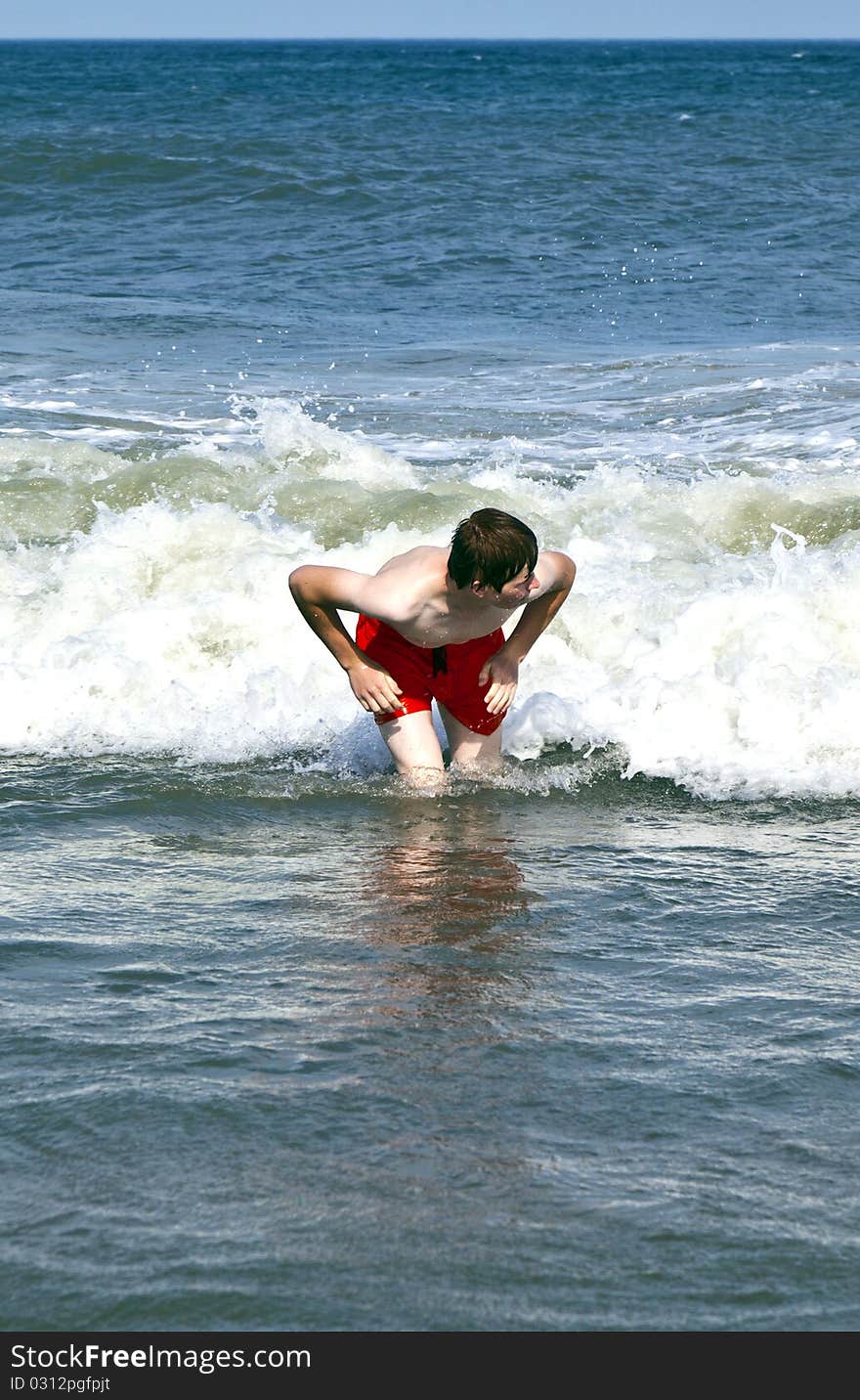 Young boy is body surfing in the waves