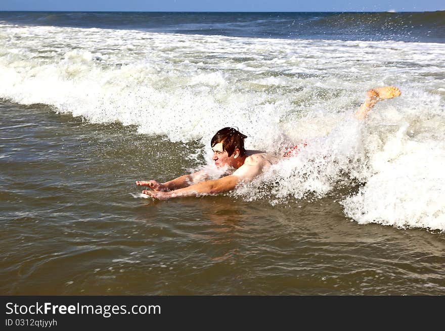 Young boy is body surfing in the waves