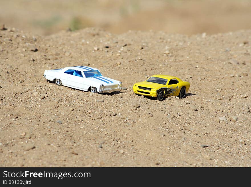 Two toy cars parked on a hill. Two toy cars parked on a hill.