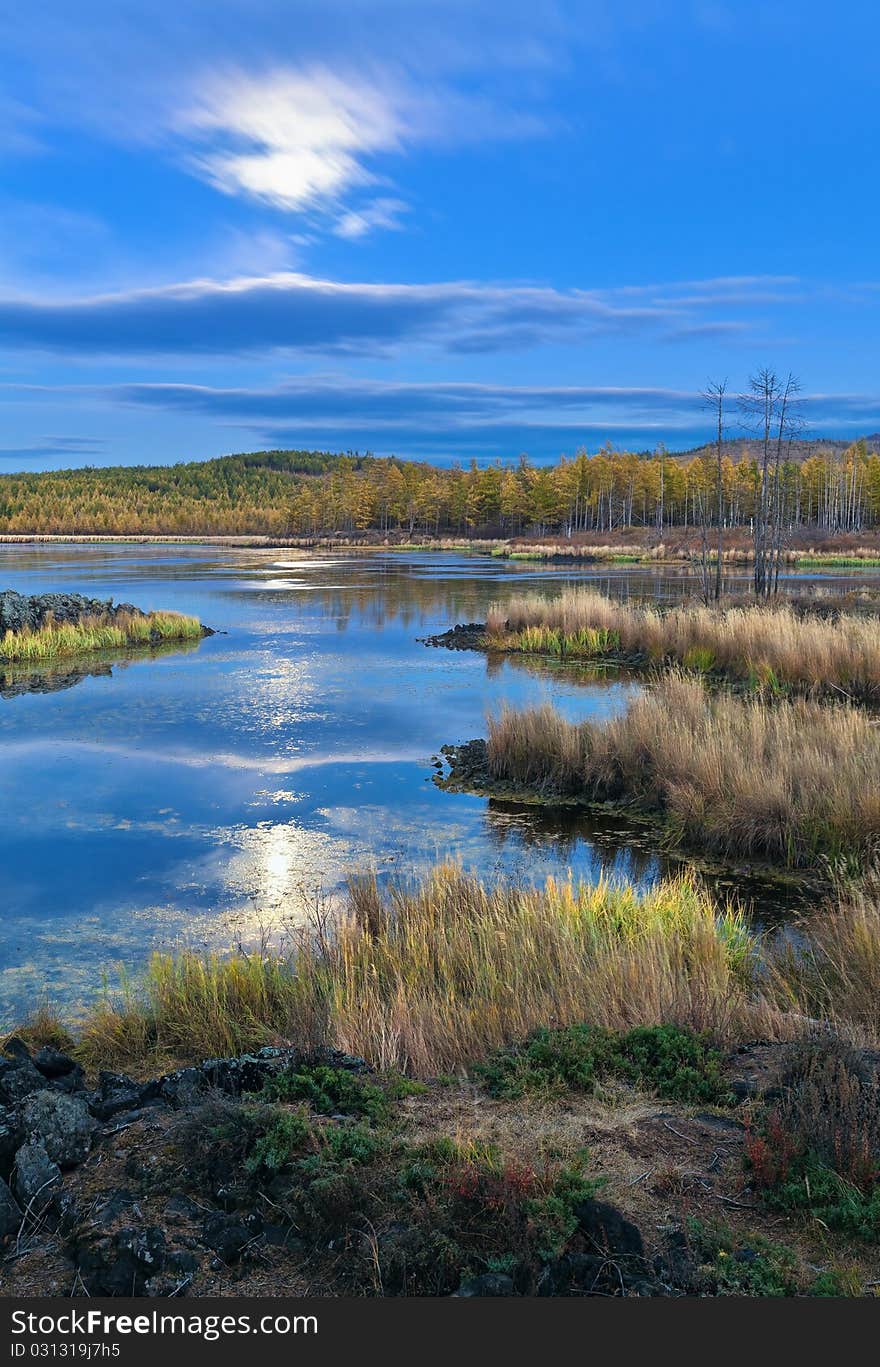 This is a picture of the sunrises under the lake and forest.