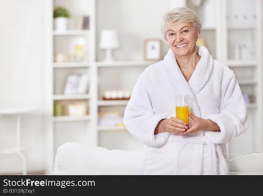 Attractive woman in a bathrobe with a glass of juice. Attractive woman in a bathrobe with a glass of juice