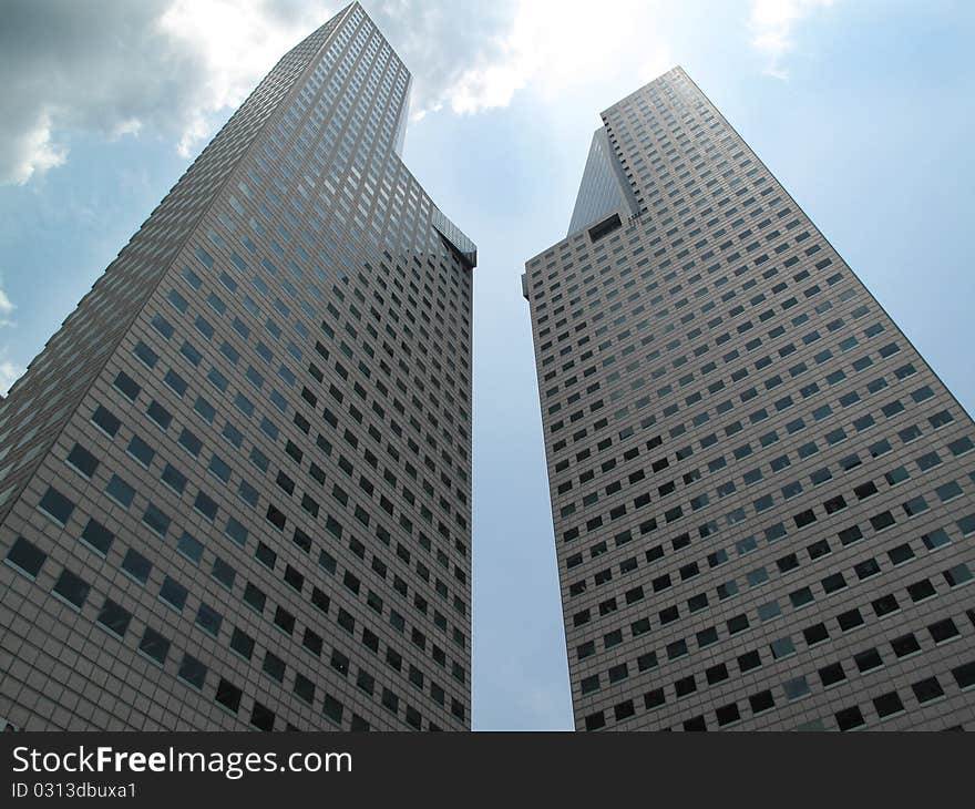 Two tall modern buildings soaring to a cloudy sky. Two tall modern buildings soaring to a cloudy sky.