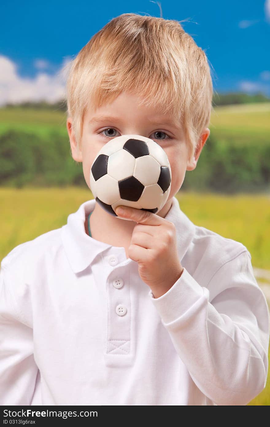 Four year old boy holding football on natural background. Four year old boy holding football on natural background