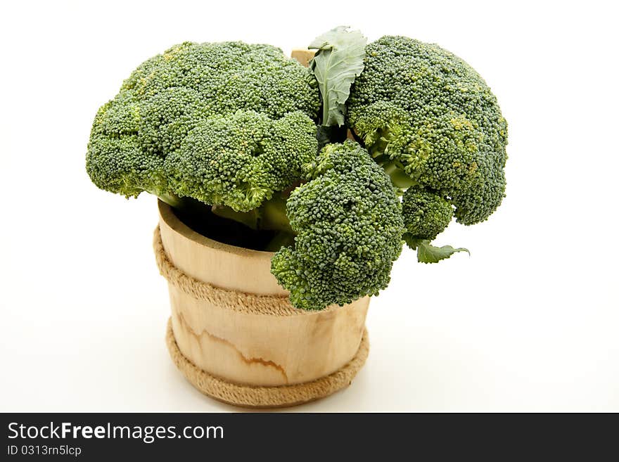 Broccoli in wood receptacle onto white background