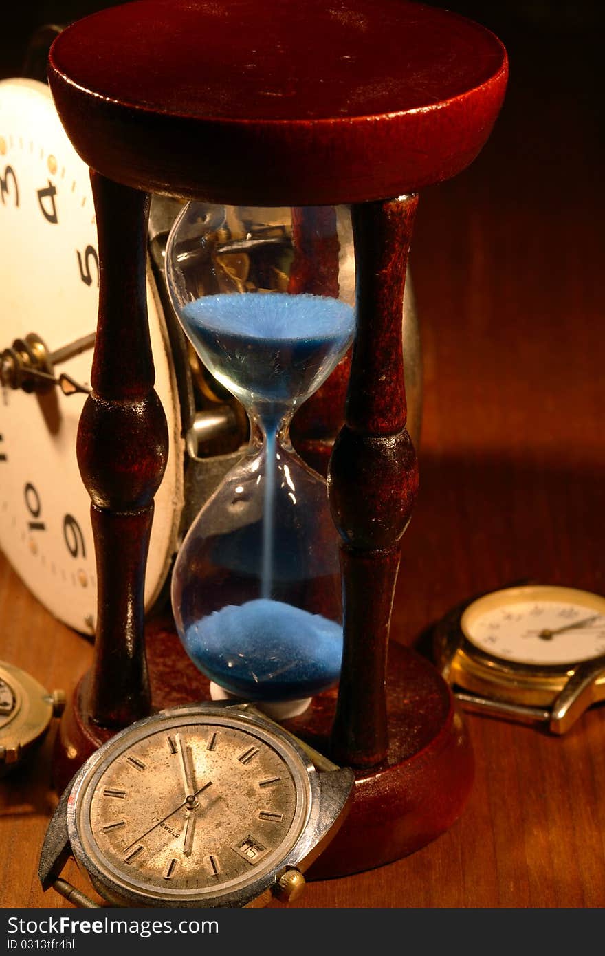 Hourglass, old watch and clock mechanism on wooden background. Hourglass, old watch and clock mechanism on wooden background