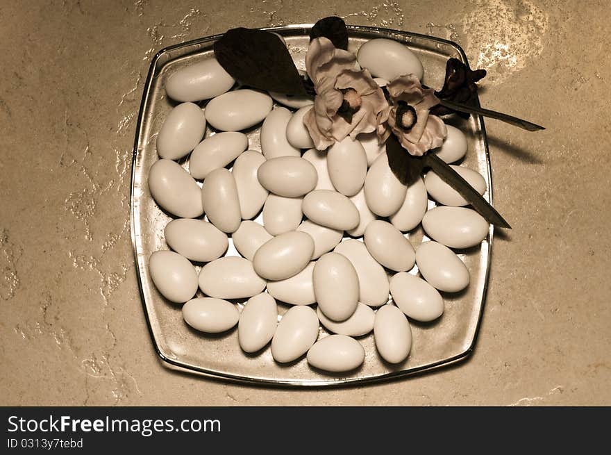 An old-looking shot of a plate filled with sugared almonds. An old-looking shot of a plate filled with sugared almonds