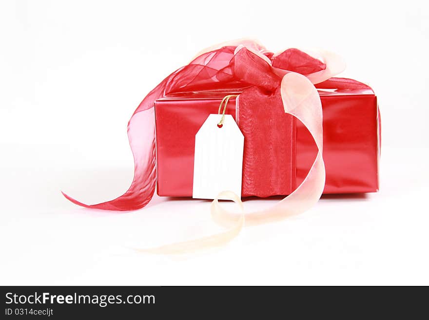 Red christmas gift box with blank tag isolated on white background