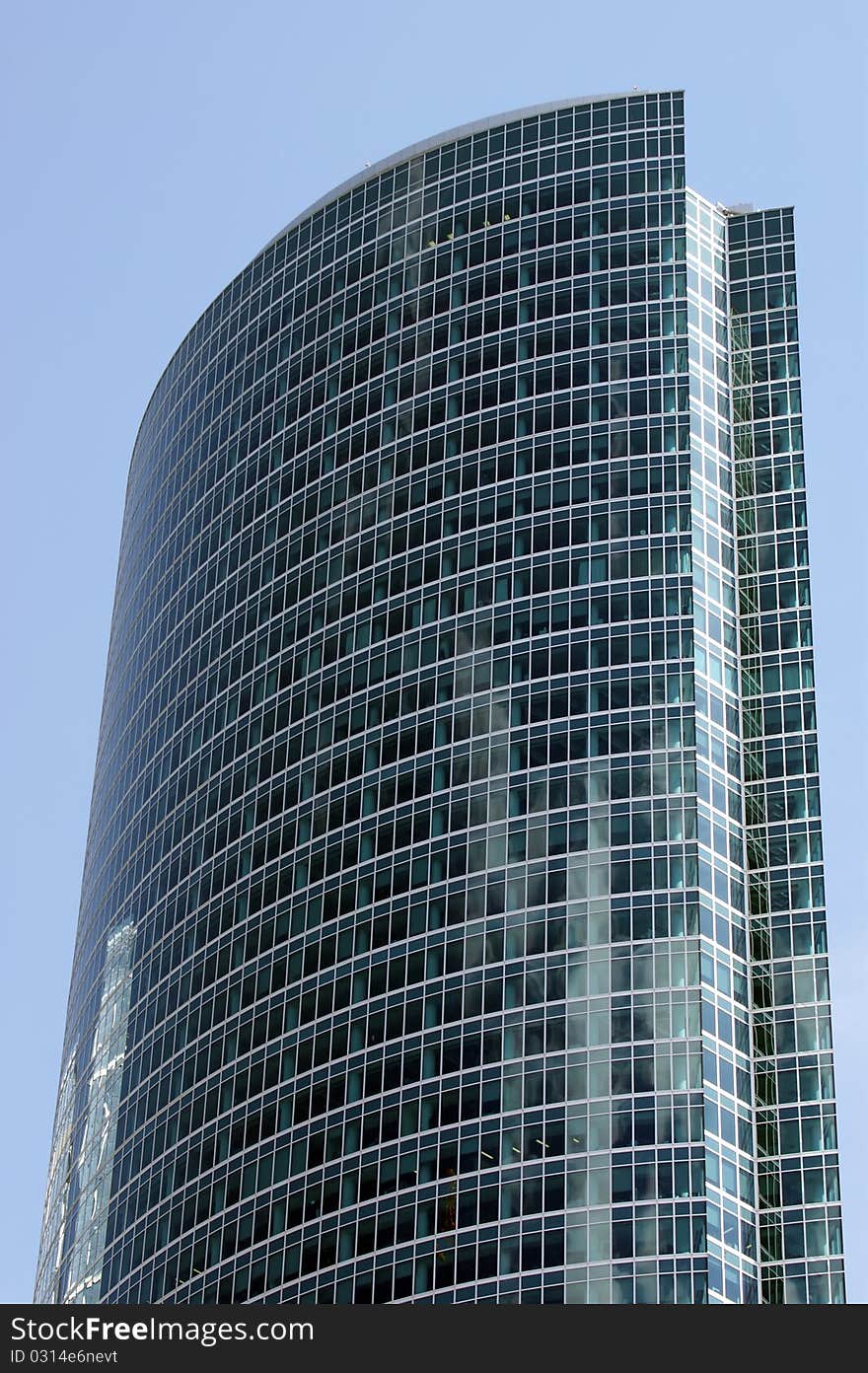 Reflection of a cloudy sky in glass wall of an office building