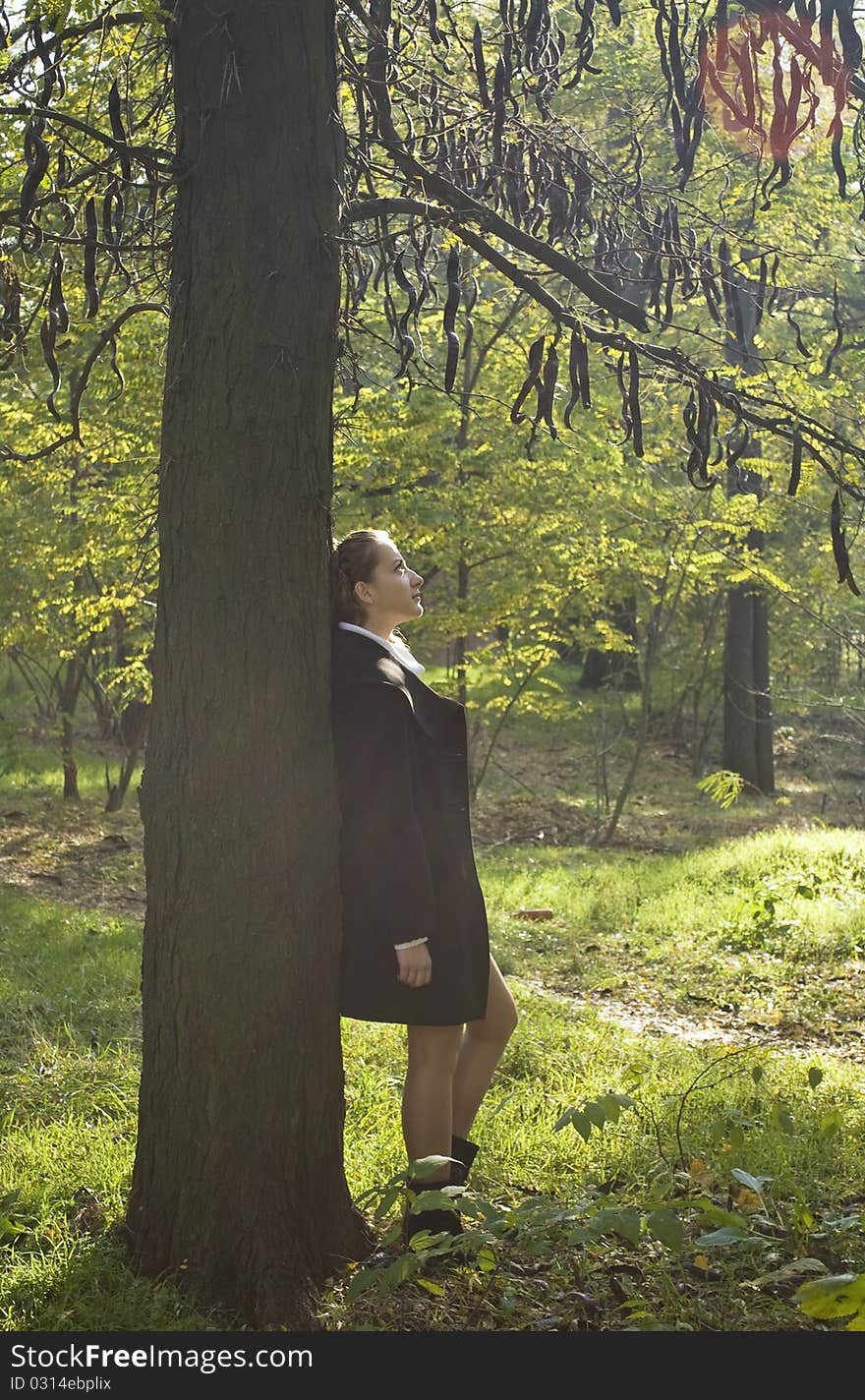 Girl dreaming under the dark mysterious tree