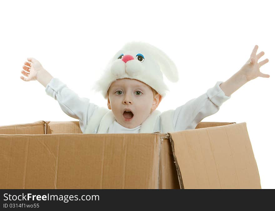 The boy in a suit of a rabbit jumps out of a box with the lifted hands