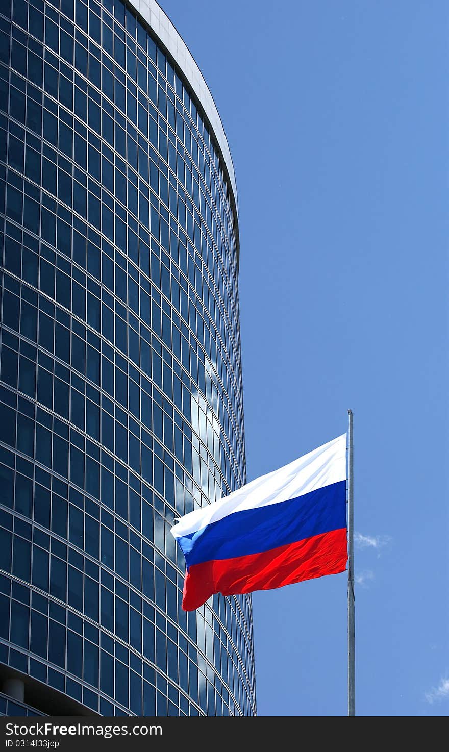 Russian flag on the background of the windows of office building