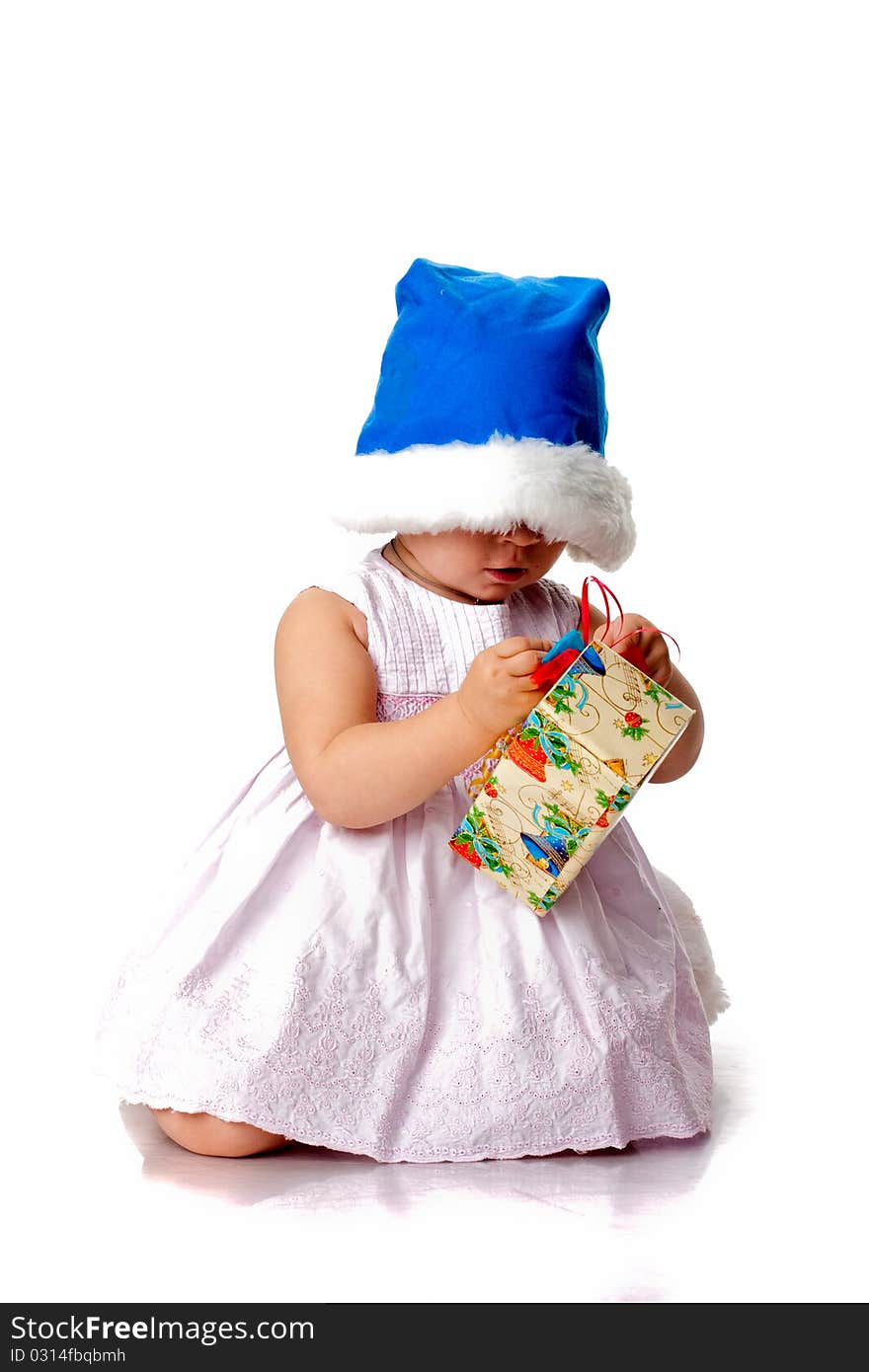 Beautiful baby in Santa's hat with a present isolated on white