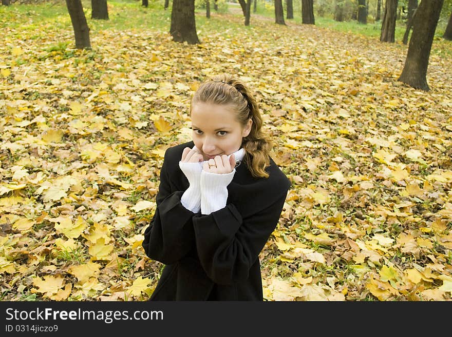 Teen Girl Warms Herself In Cold Autumn Park